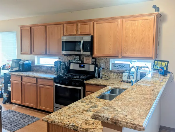 a kitchen with stainless steel appliances granite countertop a sink stove and refrigerator
