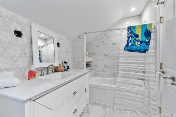 a bathroom with a sink mirror and vanity
