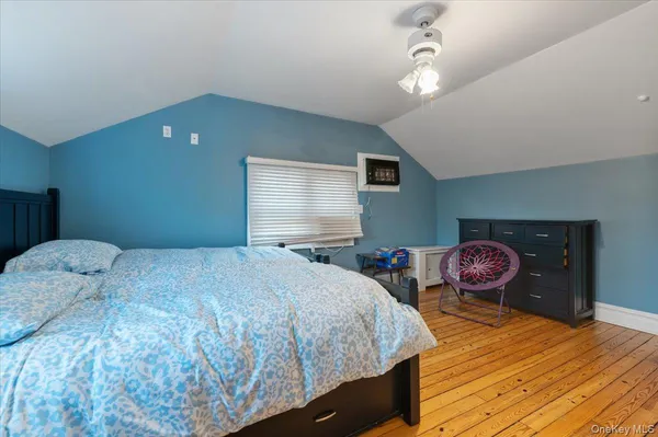 a bedroom with a bed and dresser with mirror