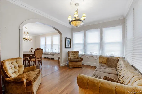 a living room with furniture a chandelier and a dining table