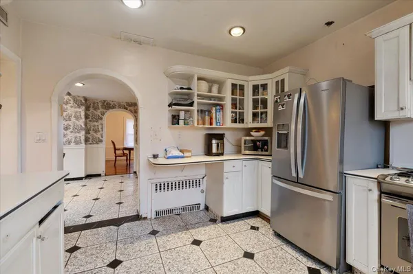 a kitchen with stainless steel appliances kitchen island granite countertop a refrigerator and a sink