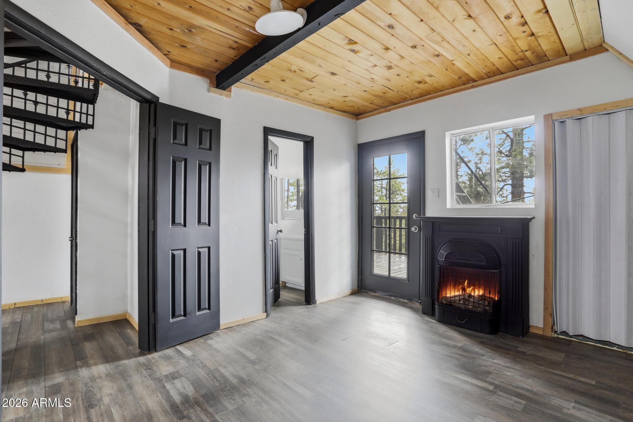 1725 Turkey Mountain Road Happy Jack, AZ 86024 - Photo 7 of 18 a view of an empty room with wooden floor fireplace and a window