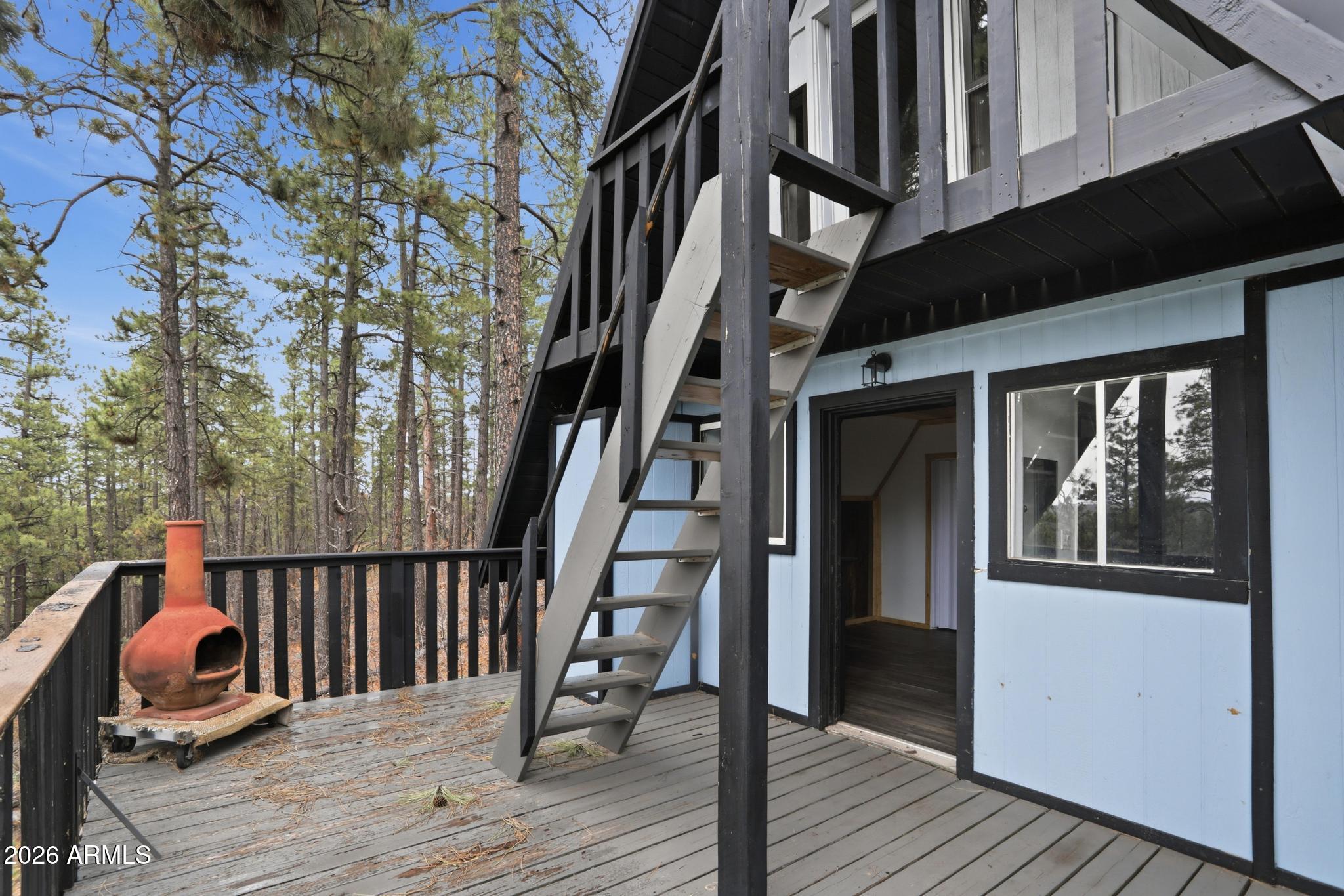 1725 Turkey Mountain Road Happy Jack, AZ 86024 - Photo 10 of 18 a view of a house with wooden deck stairs and wooden floor
