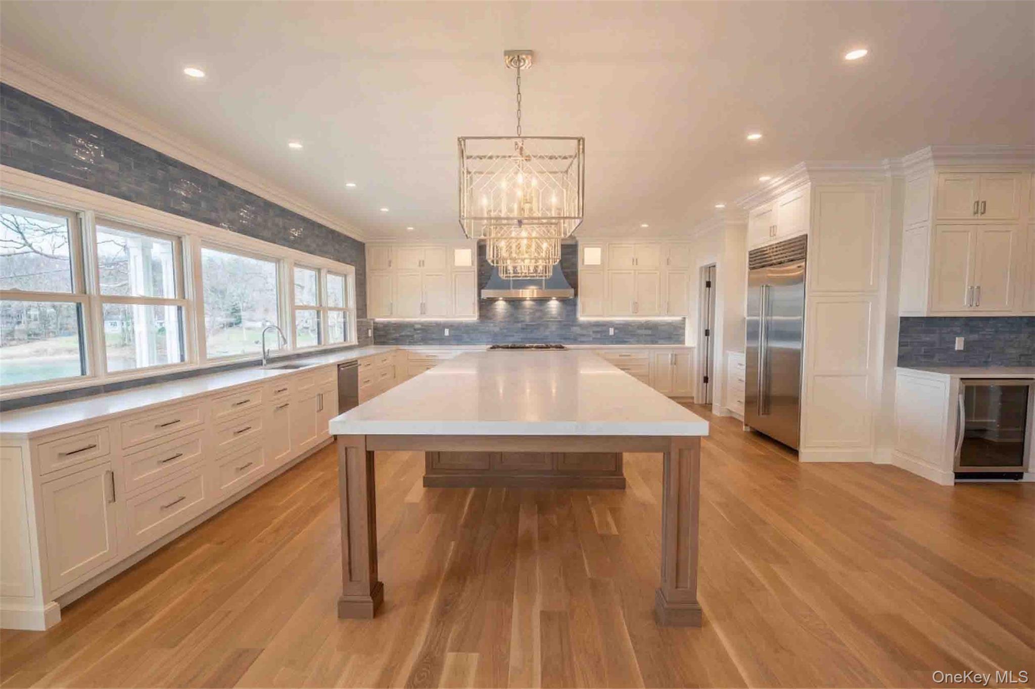 106 Cove Road Asharoken, NY 11768 - Photo 9 of 46 Kitchen featuring beverage cooler, crown molding, built in refrigerator, suspended lighting, and a center island