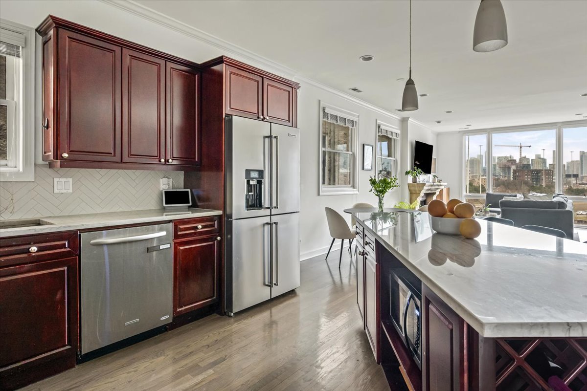 618 North May Street, Unit C Chicago, IL 60642 - Photo 13 of 30 a kitchen with stainless steel appliances granite countertop a refrigerator a sink dishwasher a stove and a dining table with wooden floor