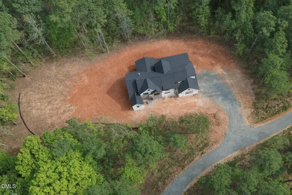 an aerial view of a house with a yard and lake view