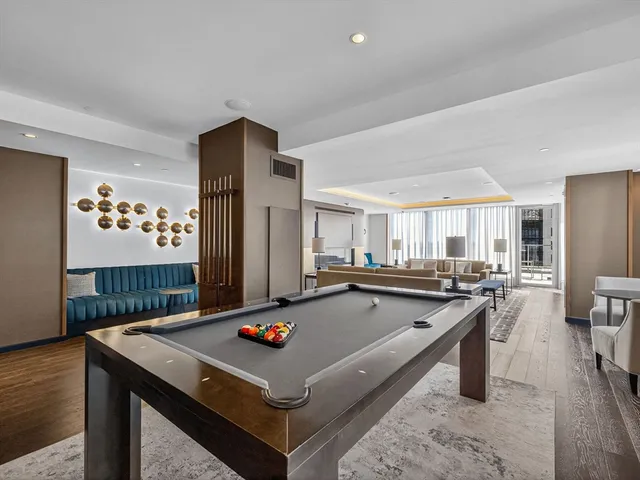 a living room with stainless steel appliances furniture stove and wooden floor