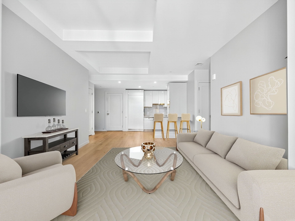 135 Seaport Boulevard, Unit 1907 Boston, MA 02210 - Photo 2 of 13 a living room with furniture and a flat screen tv