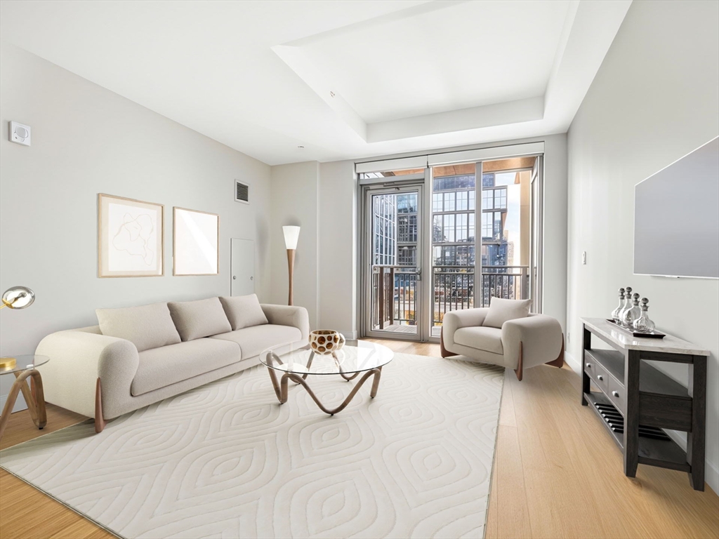 135 Seaport Boulevard, Unit 1907 Boston, MA 02210 - Photo 3 of 13 a living room with furniture and a large window