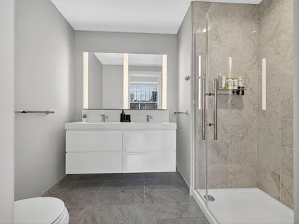 a bathroom with a sink a toilet and shower