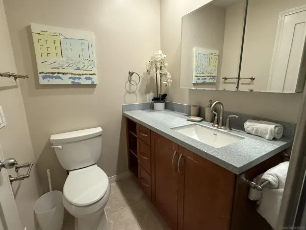 a bathroom with a granite countertop toilet sink and mirror