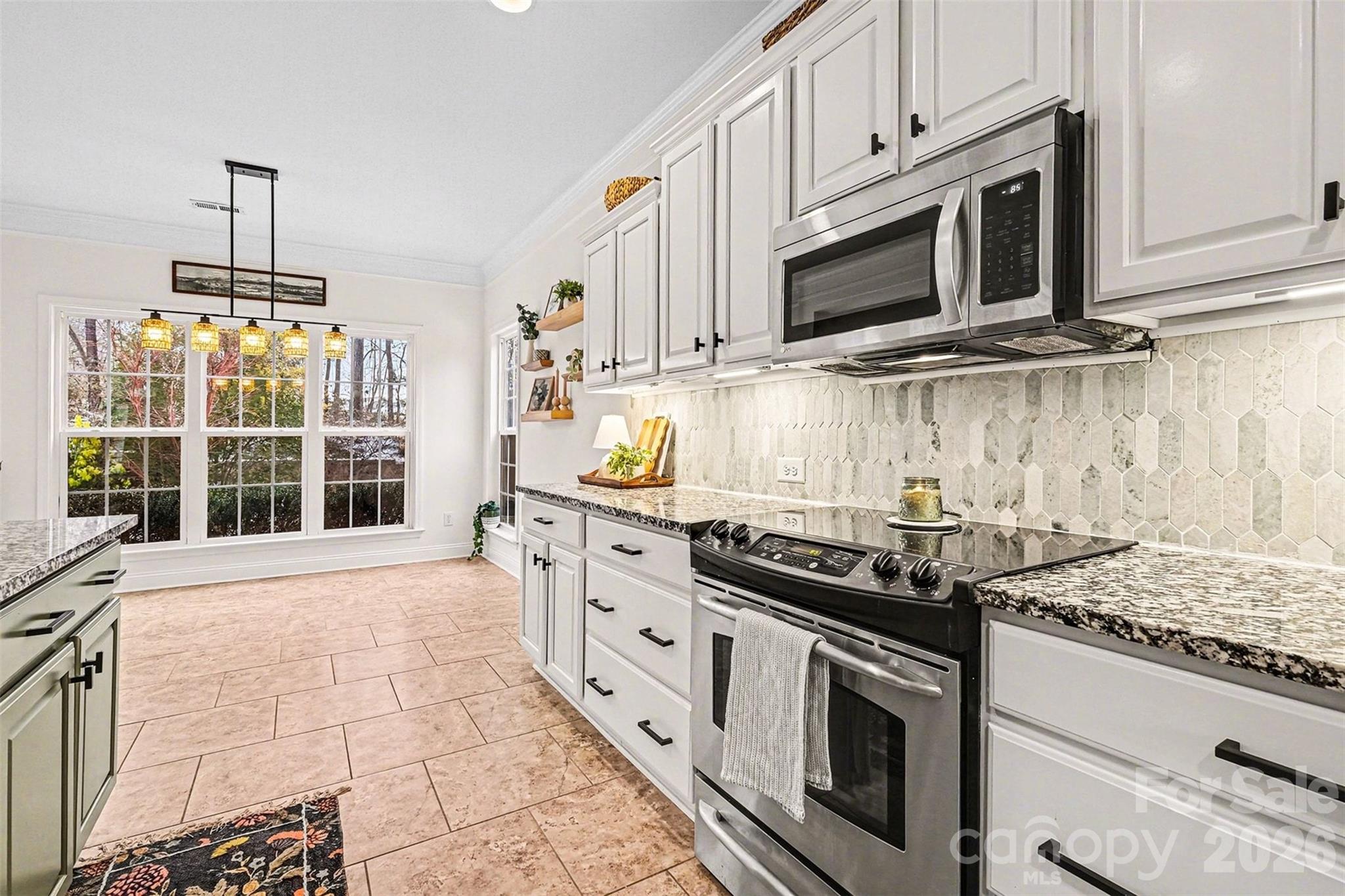 126 Burtons Barn Road Mooresville, NC 28115 - Photo 24 of 48 a kitchen with stainless steel appliances granite countertop a stove a microwave and a sink