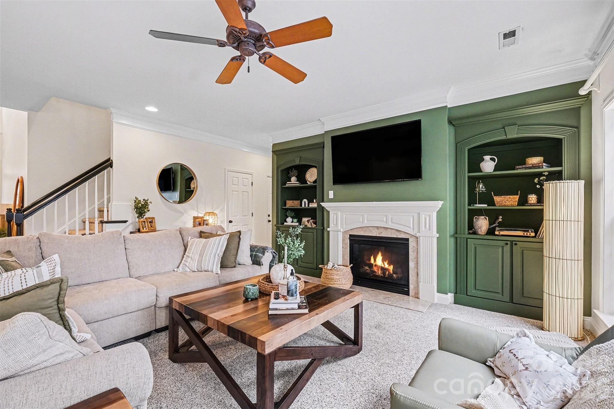 126 Burtons Barn Road Mooresville, NC 28115 - Photo 10 of 48 a living room with furniture a flat screen tv and a fireplace