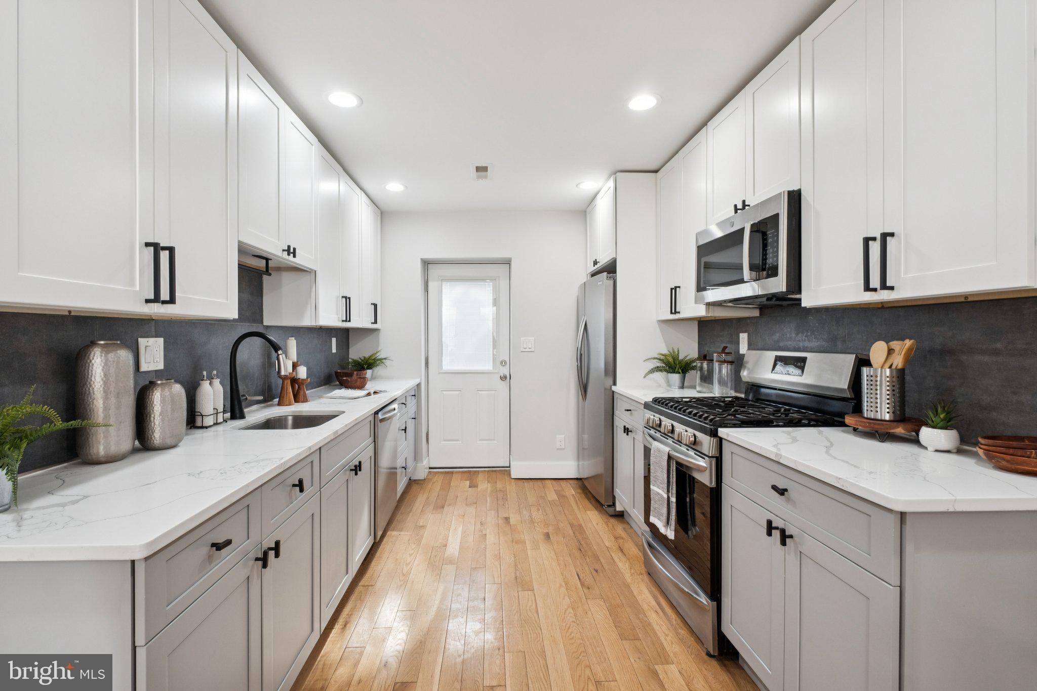 1811 Wilder Street Philadelphia, PA 19146 - Photo 11 of 37 a kitchen with stainless steel appliances granite countertop a sink a stove and a refrigerator