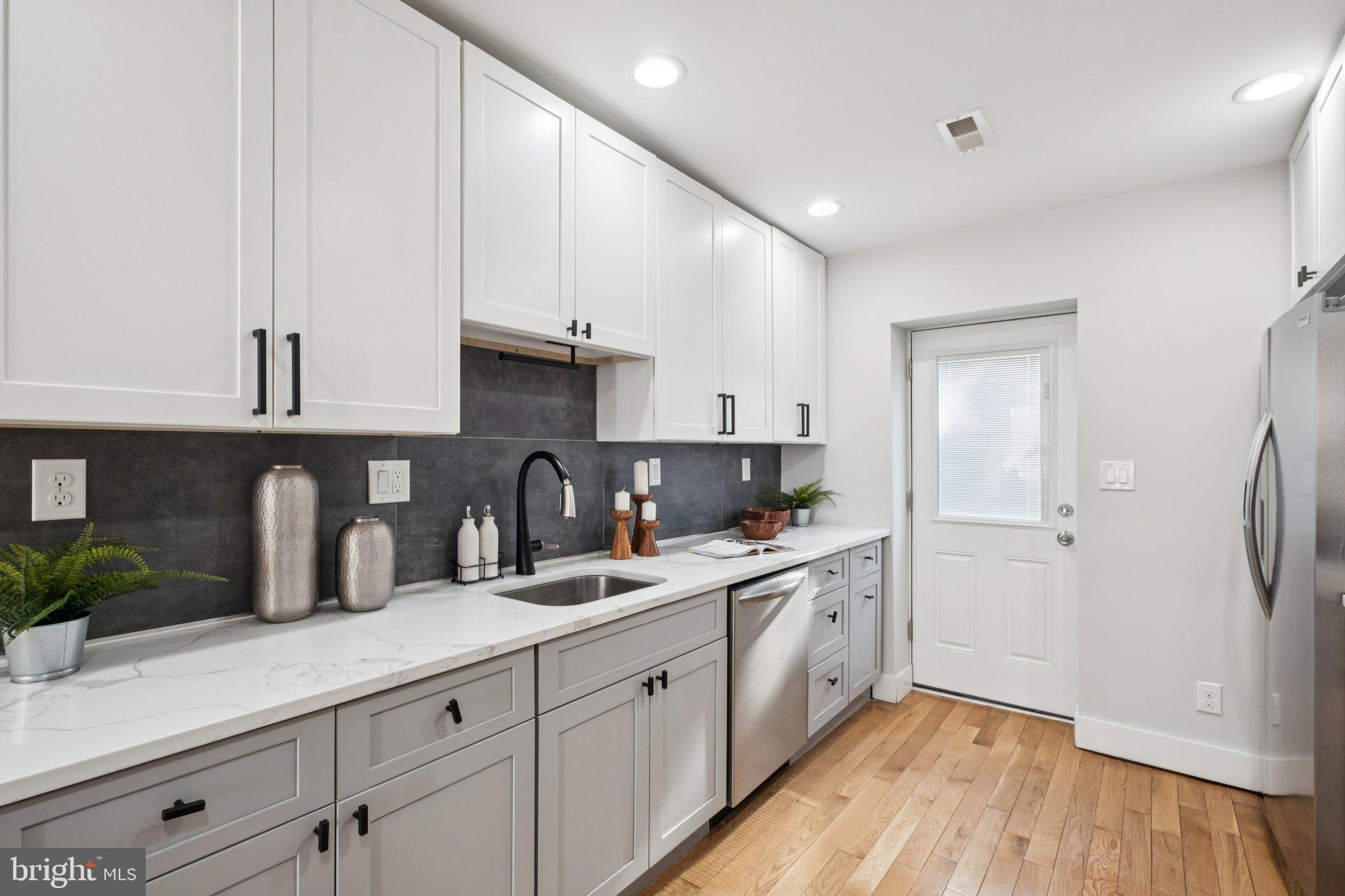 1811 Wilder Street Philadelphia, PA 19146 - Photo 12 of 37 a kitchen with white cabinets and wooden floor