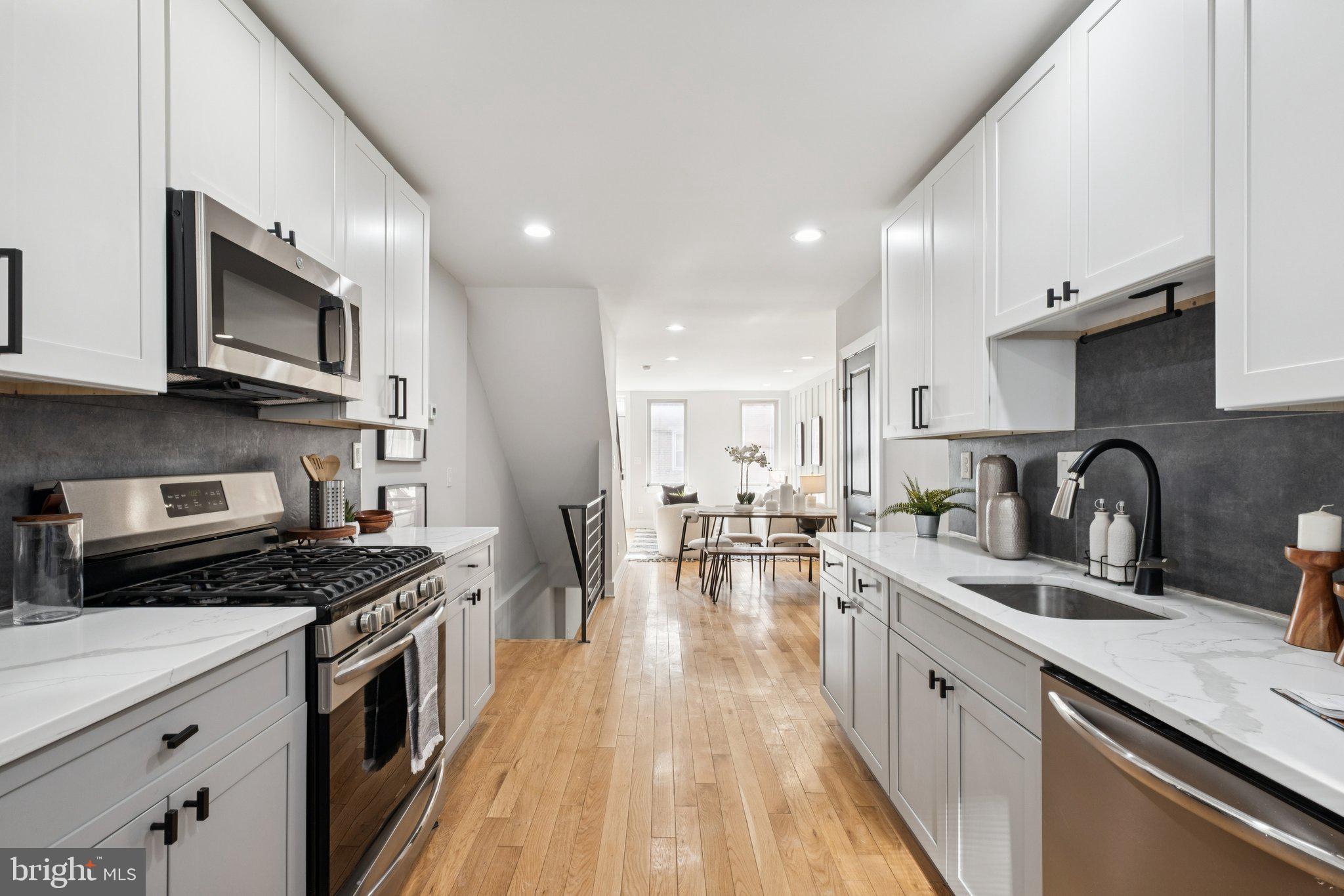 1811 Wilder Street Philadelphia, PA 19146 - Photo 14 of 37 a kitchen with stainless steel appliances a stove sink microwave and cabinets