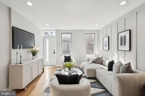 a living room with furniture a flat screen tv and a large window