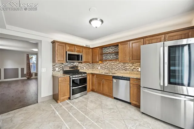 a kitchen with stainless steel appliances granite countertop a refrigerator oven a sink and dishwasher