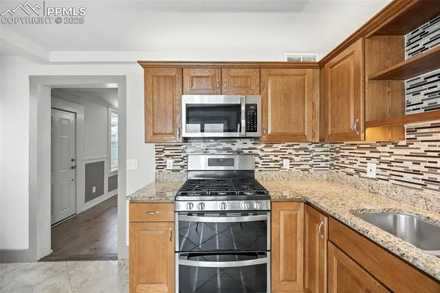 a kitchen with granite countertop a stove and a sink
