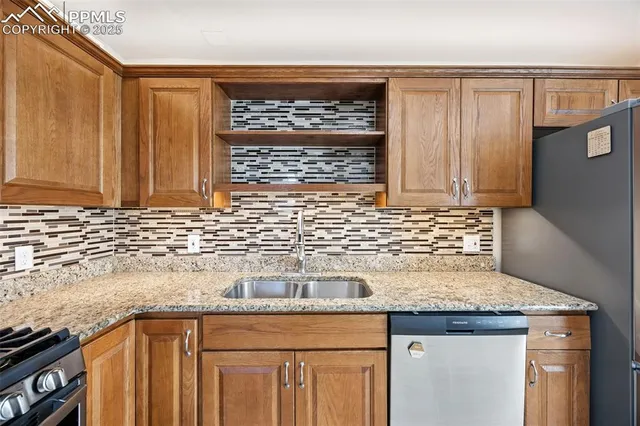 a kitchen with granite countertop a sink a stove and cabinets