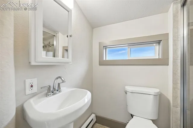 a bathroom with a toilet a sink and mirror