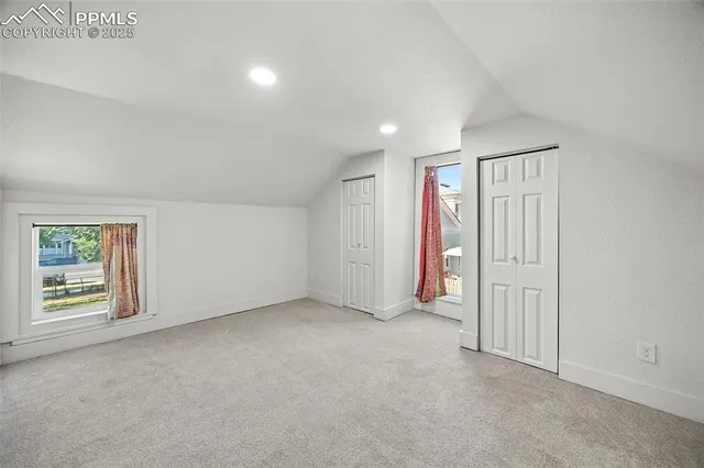 an empty room with windows and closet