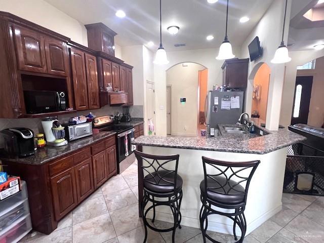 2102 Stone Gate Drive Harlingen, TX 78552 - Photo 11 of 35 a kitchen with granite countertop a stove a sink and a refrigerator