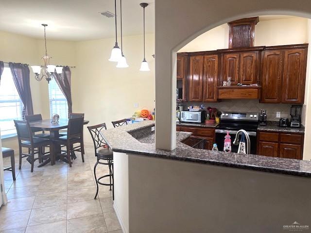 2102 Stone Gate Drive Harlingen, TX 78552 - Photo 10 of 35 a kitchen with granite countertop a table chairs stove and cabinets