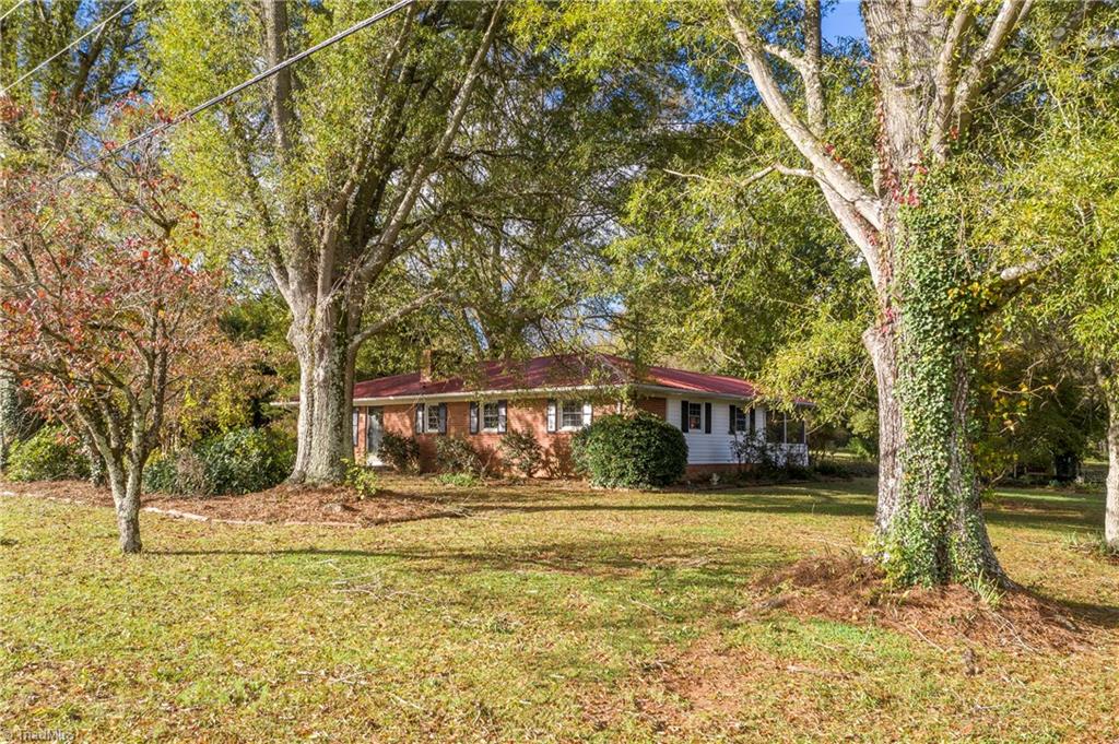 9092 Lasater Road Clemmons, NC 27012 - Photo 3 of 39 The house is set back from the road with lots of trees and landscaping