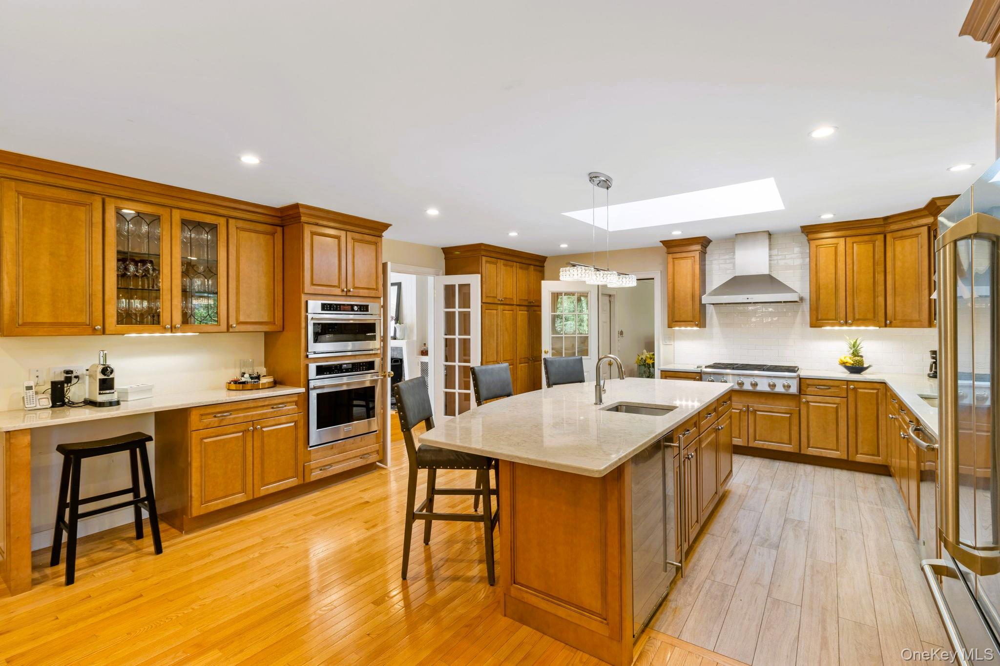 88 Spier Road Scarsdale, NY 10583 - Photo 9 of 26 Kitchen with stainless steel appliances, a skylight, and oversized island