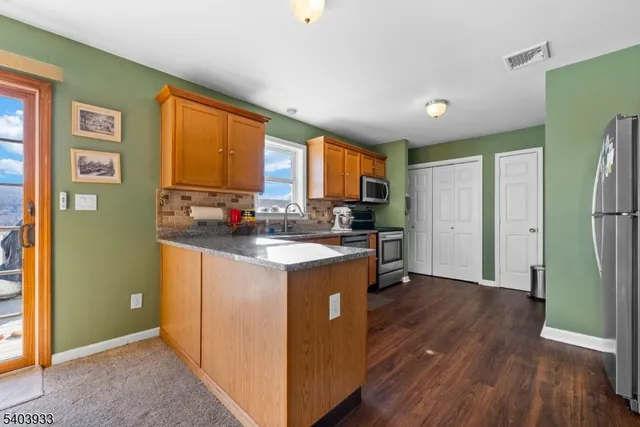 a kitchen with stainless steel appliances kitchen island granite countertop a stove and a microwave