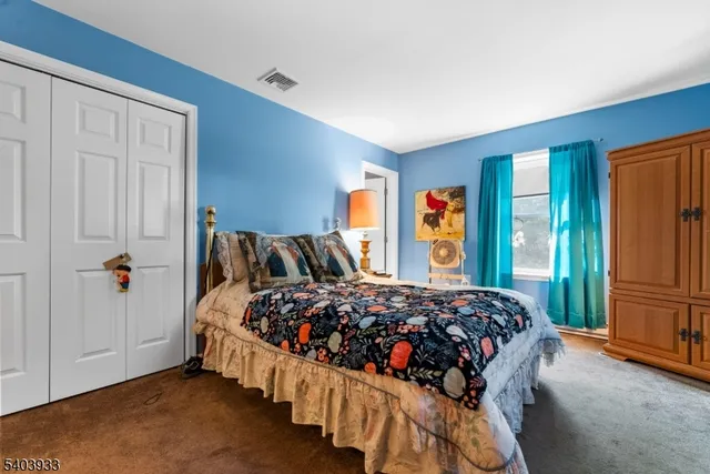 a bed sitting in a bedroom next to a window