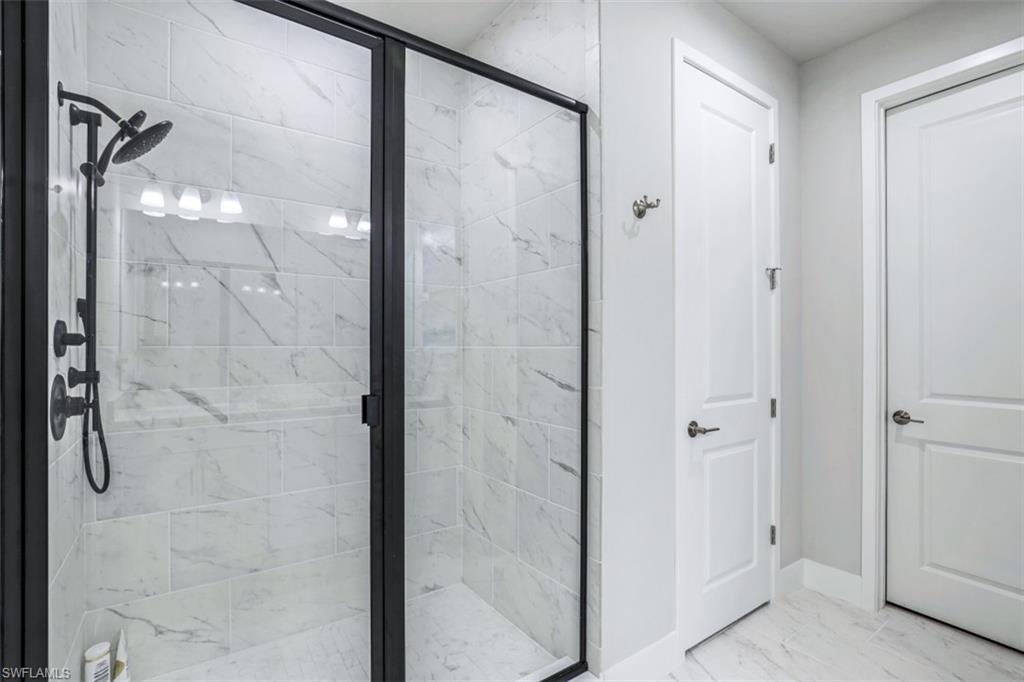 4705 Arboretum Circle, Unit 203 Naples, FL 34112 - Photo 16 of 31 a bathroom with a glass shower door