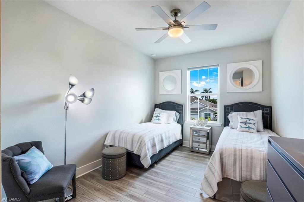 4705 Arboretum Circle, Unit 203 Naples, FL 34112 - Photo 17 of 31 a bedroom with two beds and a chandelier