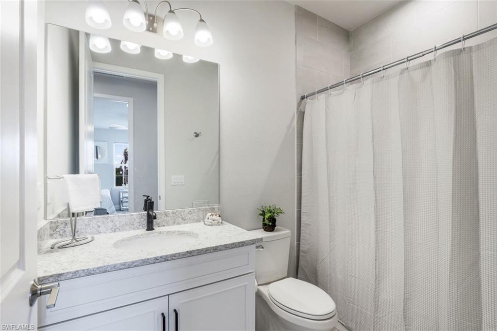4705 Arboretum Circle, Unit 203 Naples, FL 34112 - Photo 18 of 31 a bathroom with a granite countertop sink a toilet and a mirror