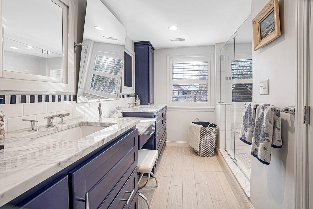 9 Madison Road Wellesley, MA 02481 - Photo 16 of 40 a bathroom with a granite countertop sink a large mirror and a bathtub