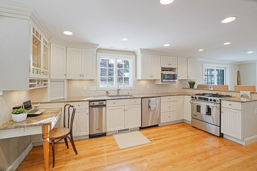 9 Madison Road Wellesley, MA 02481 - Photo 7 of 40 a kitchen with stainless steel appliances granite countertop a stove top oven a sink a dining table and chairs