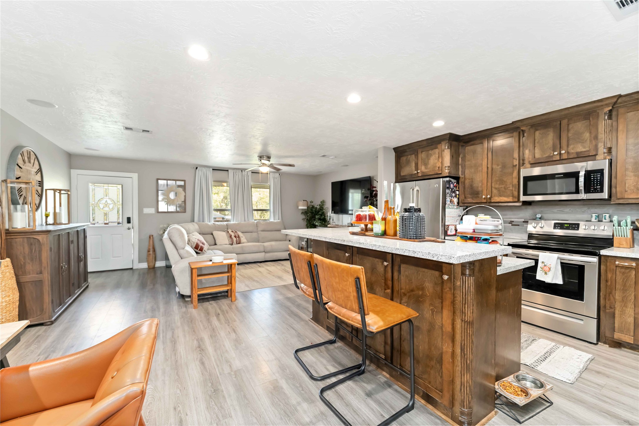2615 Commerce Street Liverpool, TX 77577 - Photo 5 of 23 a kitchen with stainless steel appliances granite countertop a stove top oven a sink dishwasher a dining table and chairs with wooden floor