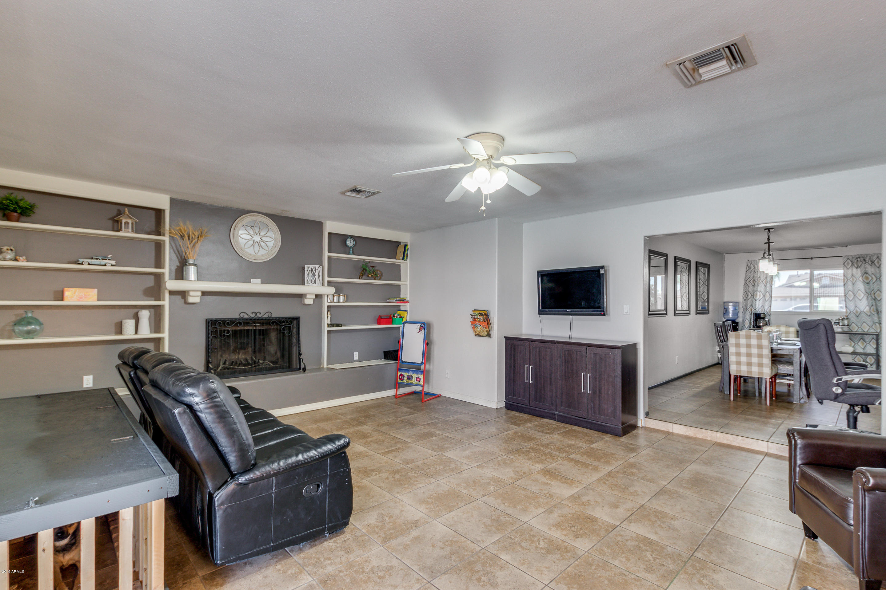 3622 West Hearn Road Phoenix, AZ 85053 - Photo 16 of 42 a living room with furniture a flat screen tv and a fireplace