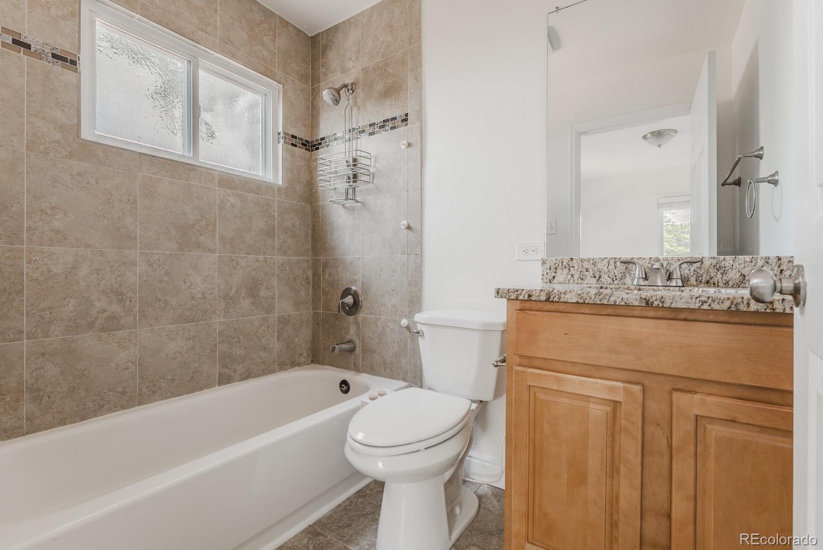 2260 Lilly Drive Thornton, CO 80229 - Photo 24 of 33 a bathroom with a granite countertop toilet sink and mirror
