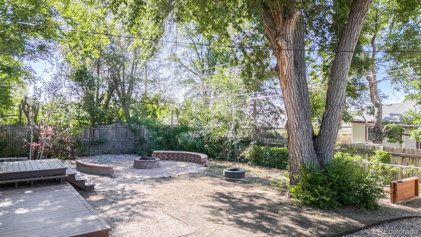 2260 Lilly Drive Thornton, CO 80229 - Photo 28 of 33 a view of a backyard with large trees and wooden fence