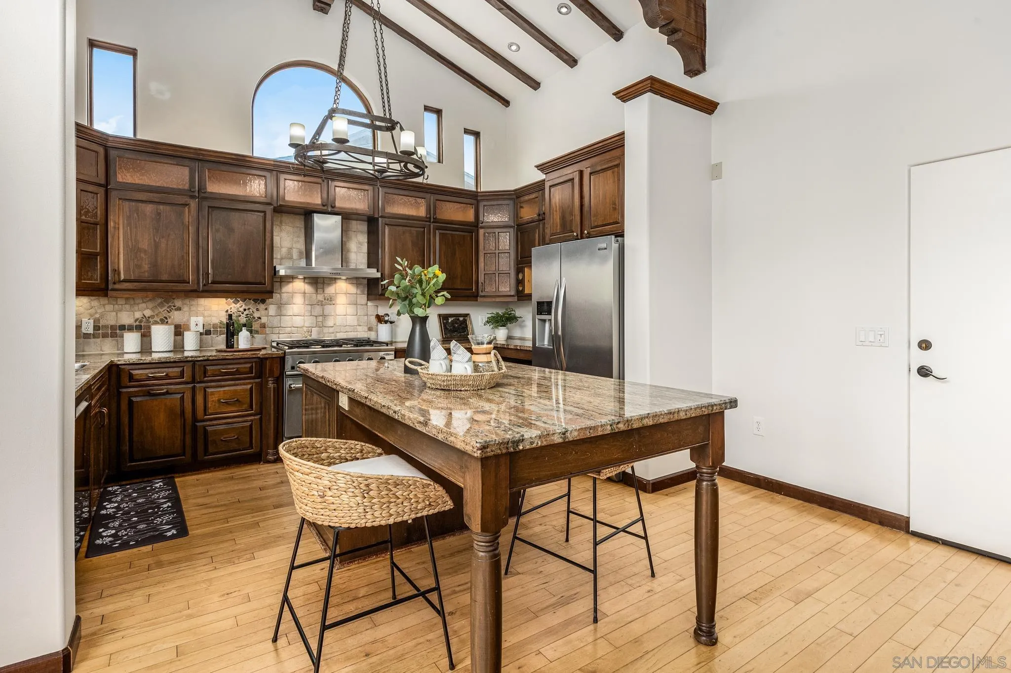 15315 Jenell Street Poway, CA 92064 - Photo 11 of 24 a kitchen with stainless steel appliances kitchen island granite countertop a table chairs in it and wooden floors