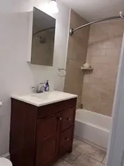 a bathroom with a sink vanity granite tub shower and a mirror