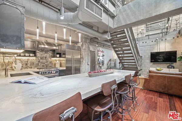 a kitchen with stainless steel appliances kitchen island granite countertop a sink and cabinets