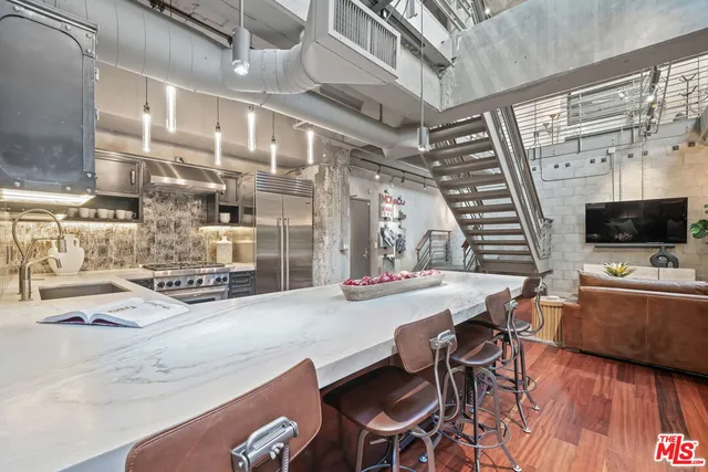a kitchen with stainless steel appliances kitchen island granite countertop a sink and cabinets