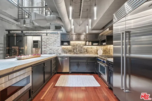 a kitchen with stainless steel appliances granite countertop a sink a counter space stainless steel appliances and cabinets