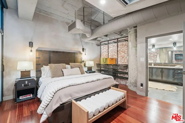 a large bedroom with a bed and wooden floor