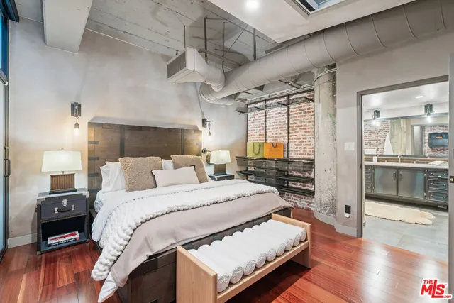 a large bedroom with a bed and wooden floor