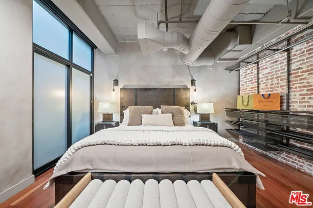 a bedroom with a bed and a flat tv screen on the dresser