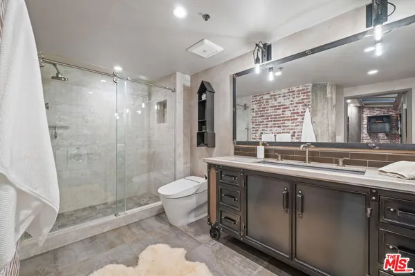 a bathroom with a double vanity sink toilet and shower